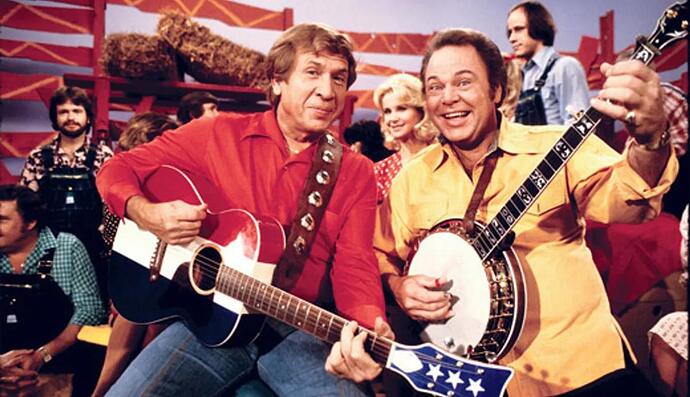roy-clark-in-a-familiar-pose-pickin-and-grinnin-with-his-co-host-buck-owens-on-the-set-of-hee-haw